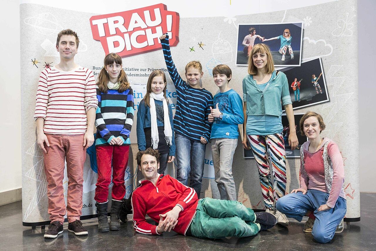 Die Schauspieler und Kinder zusammen vor dem Banner der Initiative Trau dich